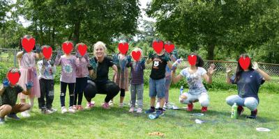 Kinderen laten hun met verf besmeurde handen aan de camera zien